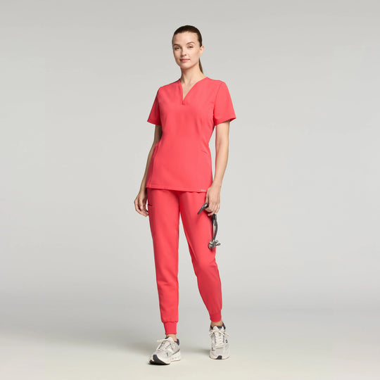 Jaanuu Scrubs Women's Calix Fit & Flare Scrub Top Coral | scrub-supply.com